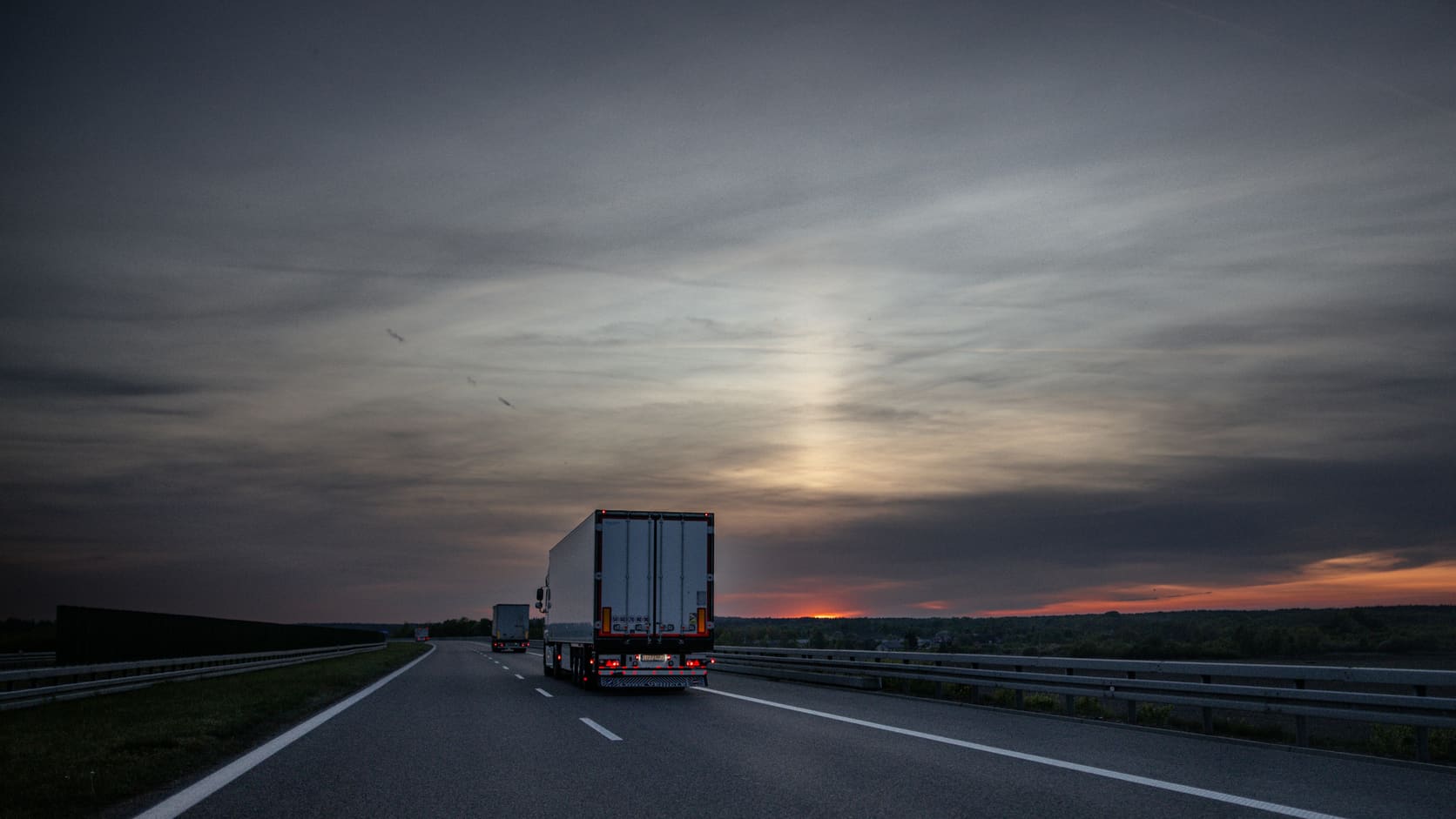 Illustrative freight truck on a highway at dusk